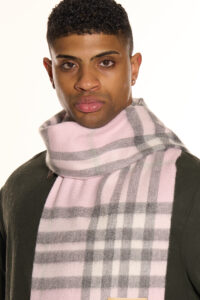 A male model wearing a beige cashmere scarf outdoors.